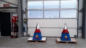 Zwei Grundgeräte mit Kegelspalter stehen vor einem weißen Hallentor von Deitmer Maschinenbau.