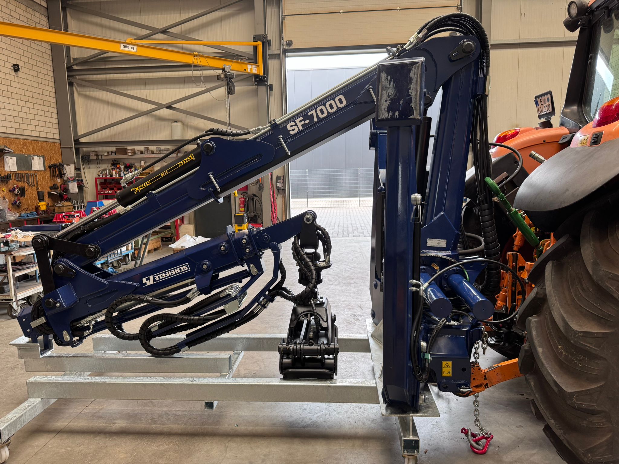 SF-7000 Der Forstkran wird in der Halle an einen Traktor befestigt.